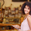 Mixed race woman standing in the door of her cafe